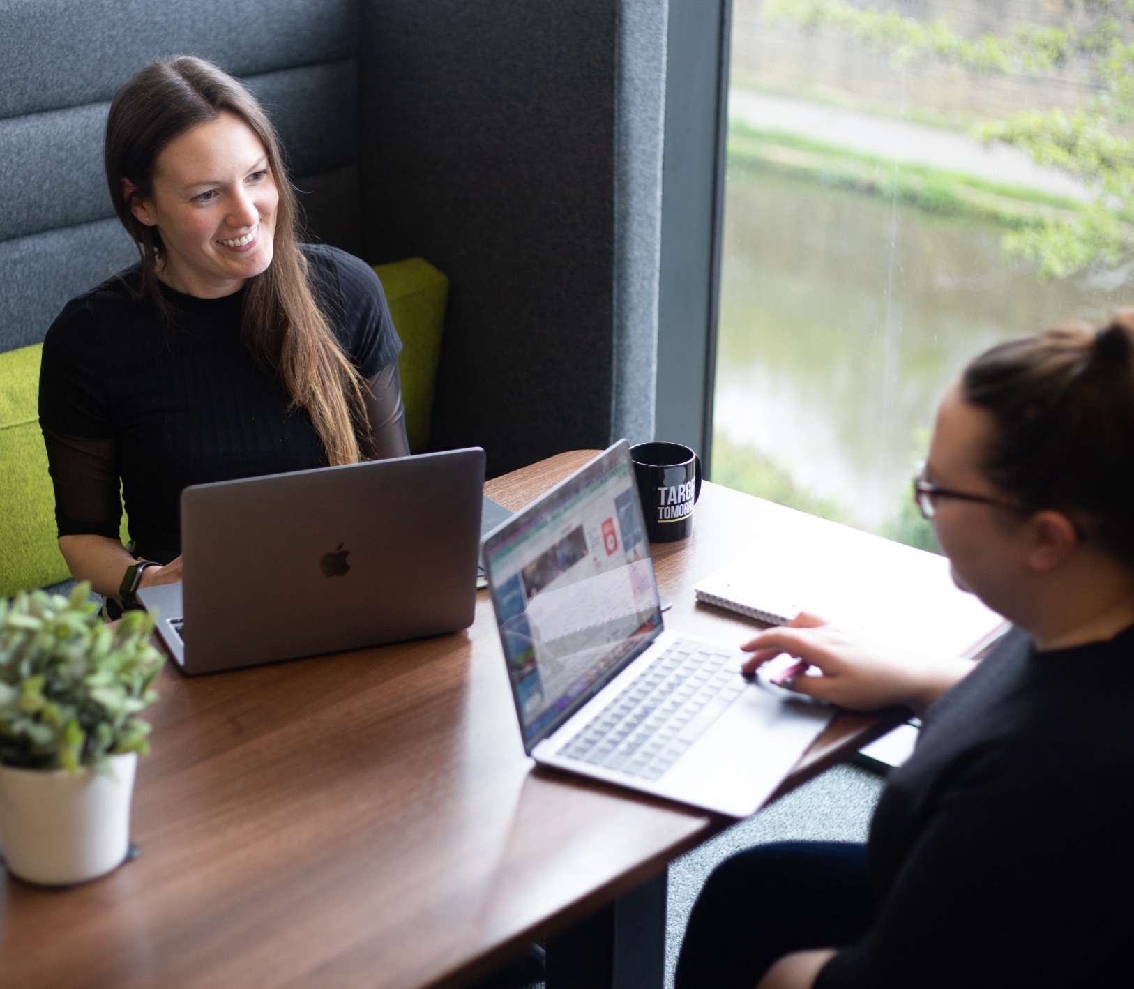 two people with laptops having a meeting